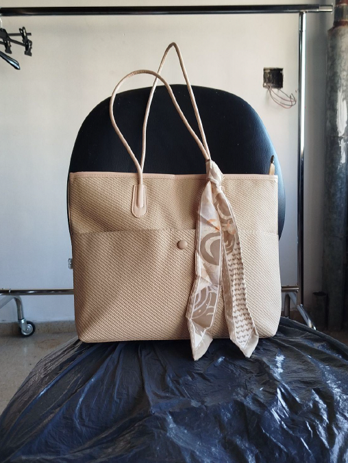 Bolso de rafia fotografiado con el celular en el taller